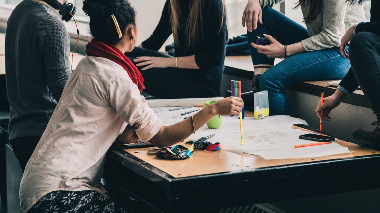 Opiskelijoita pöydän ääressä opiskelemassa ryhmässä